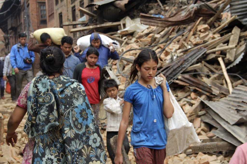 Earthquake survivors make their way past piles of rubble in Kathmandu, Nepal. Accessing affected rural villages remains a significant challenge, say United Methodist missionaries assigned there. 