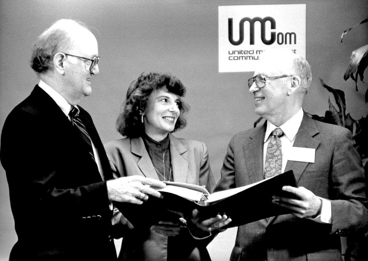 Roger Burgess (right), top staff executive of United Methodist Communications, visits with members of the Commission on Communications John Lovelace (left) and the Rev. Joan Gray in this UMCom file photo. Photo ca. 1989.