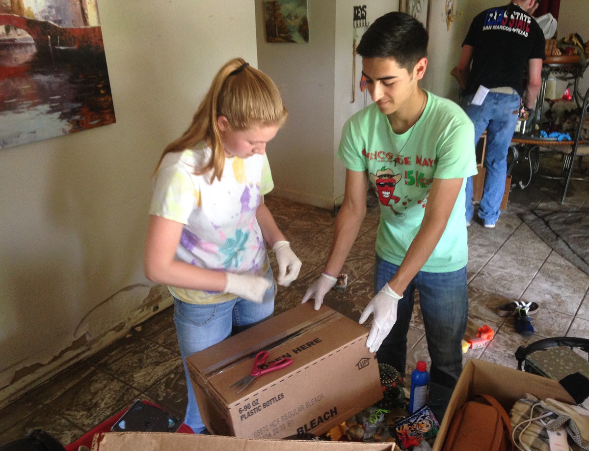An online ministry of First United Methodist Church in San Marcos, Texas, helped recruit and organize volunteers to help with flood relief there. Students from San Marcos High School and Texas State University removed items from a flooded home in San Marcos' Blanco Garden area. Photo by the Rev. Todd Salmi