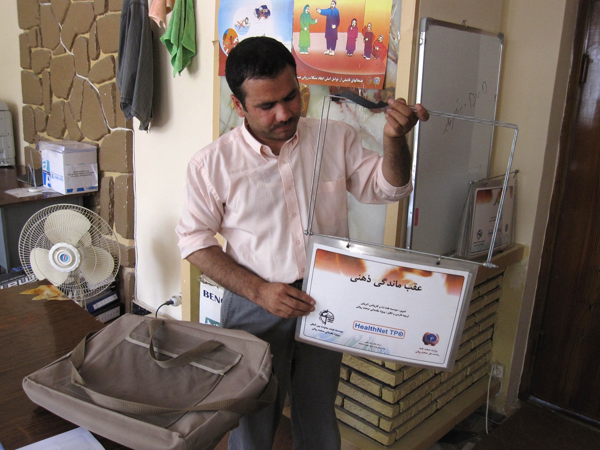 A trainer for a community mental health project in Afghanistan holds a flip chart used in the mental health awareness program for police, teachers, health care providers, mullahs and other community leaders.
