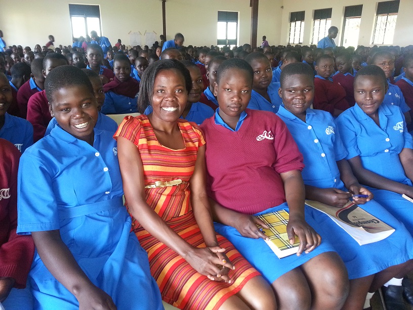 Lillian Achom spoke about technology careers at a career day at Tororo Girls School in Tororo, Uganda, near Kampala. Achom, in the orange dress, is an Africa University graduate. She works with Afchix to encourage girls and young women to take science and technology classes. Photo courtesy of Lillian Achom