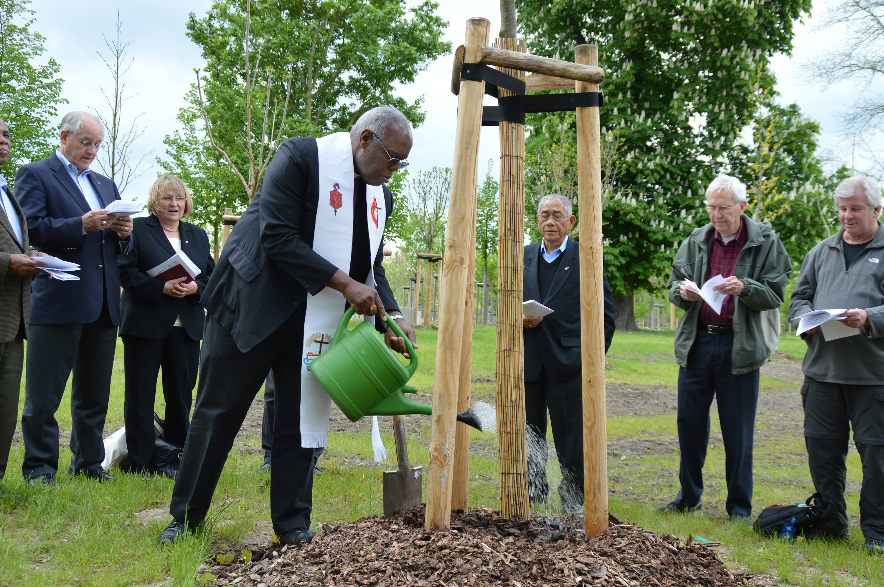 San Francisco Area Bishop Warner Brown Jr., president of the Council of Bishops, waters a newly planted tree in the Luther Garden in Wittenberg, Germany. The Lutheran World Federation is inviting churches around the globe to plant a tree in the garden and another in their area as part of preparations for the 500th anniversary of the Protestant Reformation in October 2017. Photo by Klaus Ulrich Ruof