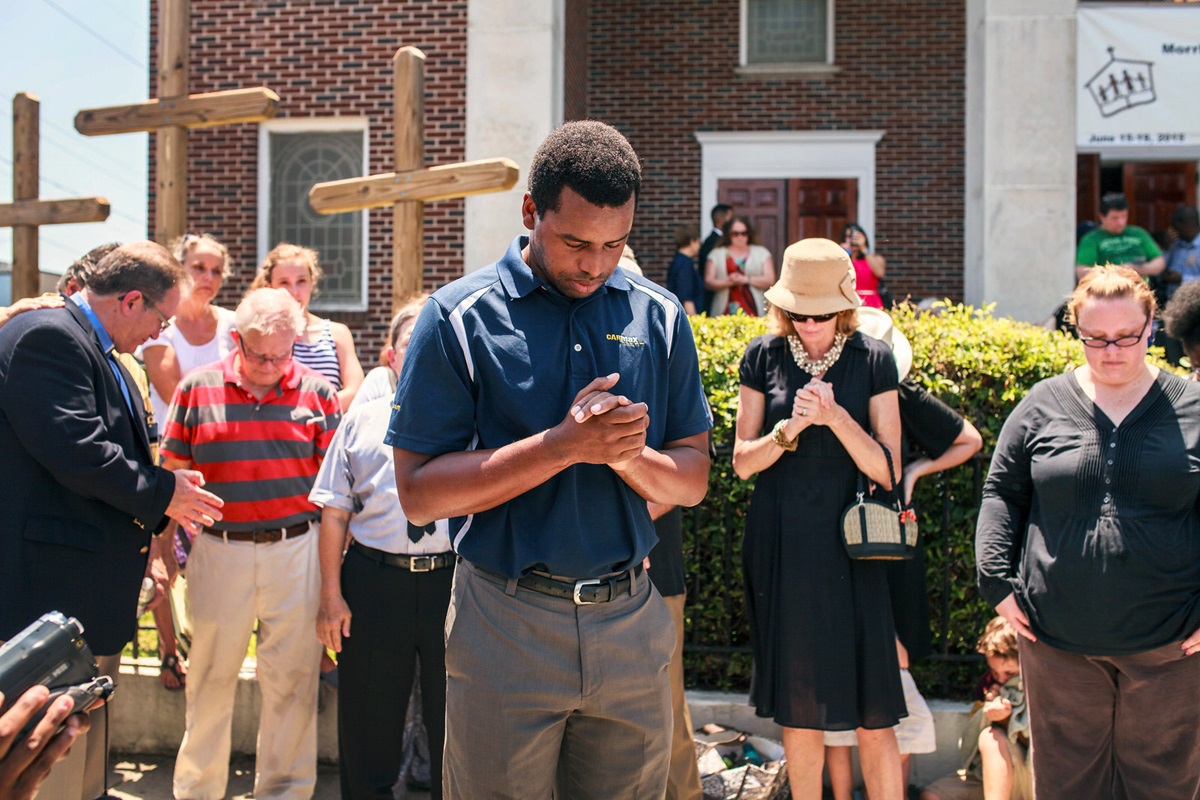 Robert Griggs (center) prays with others outside Morris Brown African Methodist Episcopal Church in Charleston, S.C. United Methodists joined AME members in prayer following the deadly shooting at Emanuel AME Church in Charleston. Photo by Lekisa Coleman-Smalls