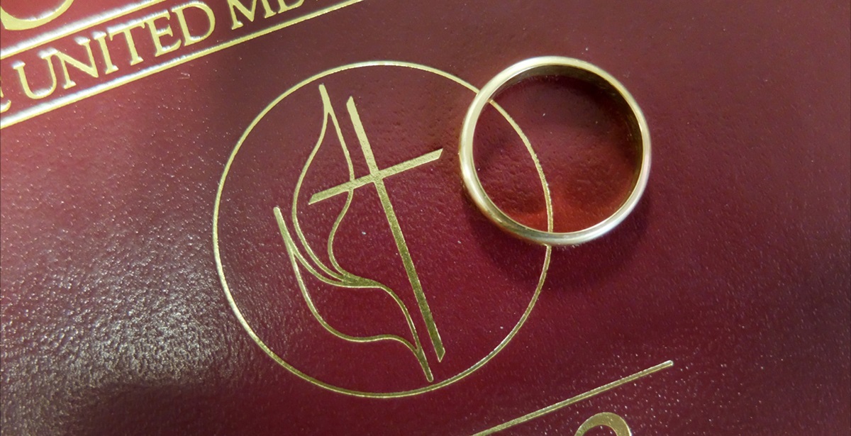 A wedding band rests on the Cross and Flame insignia of the 2012 Book of Discipline. United Methodist bishops seek to offer clarity after the U.S. Supreme Court ruled same-sex marriage legal across the United States. Photo illustration by Kathleen Barry, United Methodist Communications.