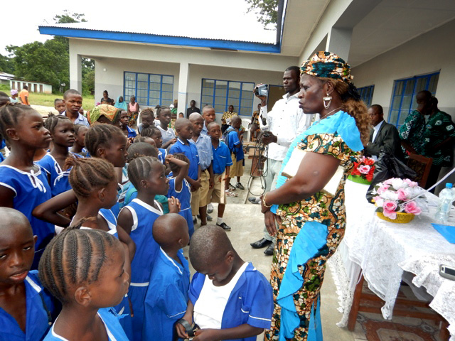 Marian Fofanah, head teacher of United Methodist Church Masorie, talks to pupils about taking care of the school. 