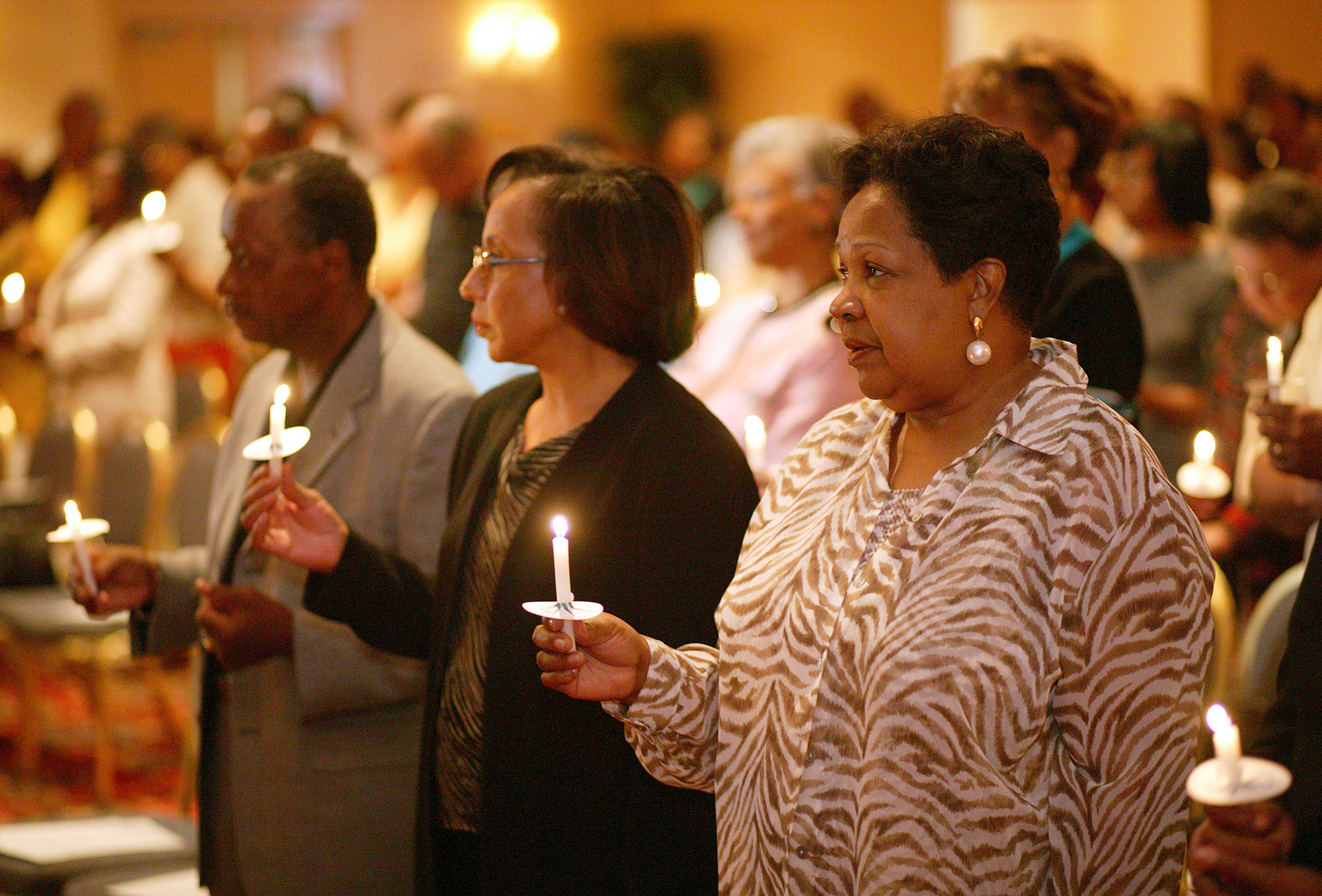 Participants at a 2004 reunion of the former Central Jurisdiction of the Methodist Church light candles in memory of those from the jurisdiction who have gone before them. The jurisdiction was a racially segregated structure for black Methodists that existed from 1939 to 1968. From left are: Earl Cleveland, Patricia White and Katie Harrison. 