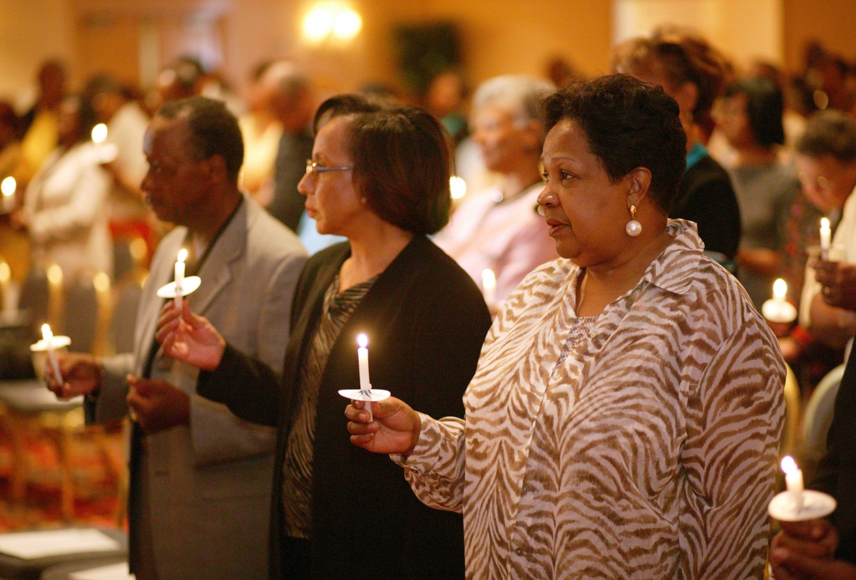 Participants at a 2004 reunion of the former Central Jurisdiction of the Methodist Church light candles in memory of those from the jurisdiction who have gone before them. The jurisdiction was a racially segregated structure for black Methodists that existed from 1939 to 1968. From left are: Earl Cleveland, Patricia White and Katie Harrison. 