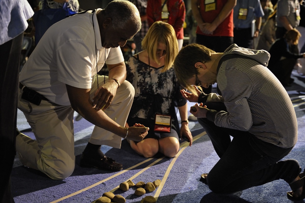 Delegates pick up stones in the center aisle during an April 27 "Act of Repentance toward Healing Relationships with Indigenous Peoples" at the 2012 United Methodist General Conference in Tampa, Florida.