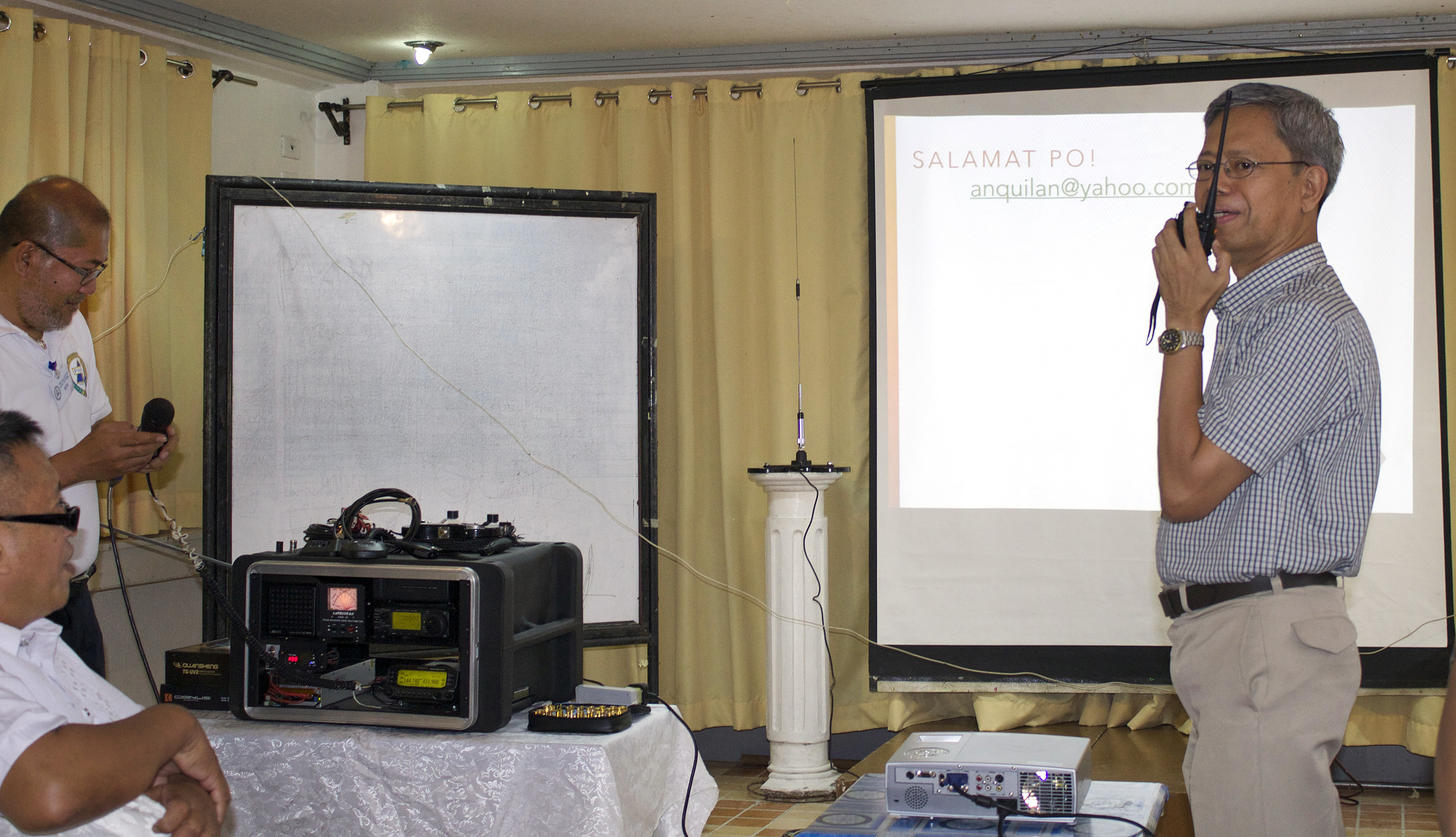 
The Rev. Jose Umali (right) tries ham radio equipment during a lecture to clergy and laity in the Philippines.  Photo courtesy of Gladys Mangiduyos
