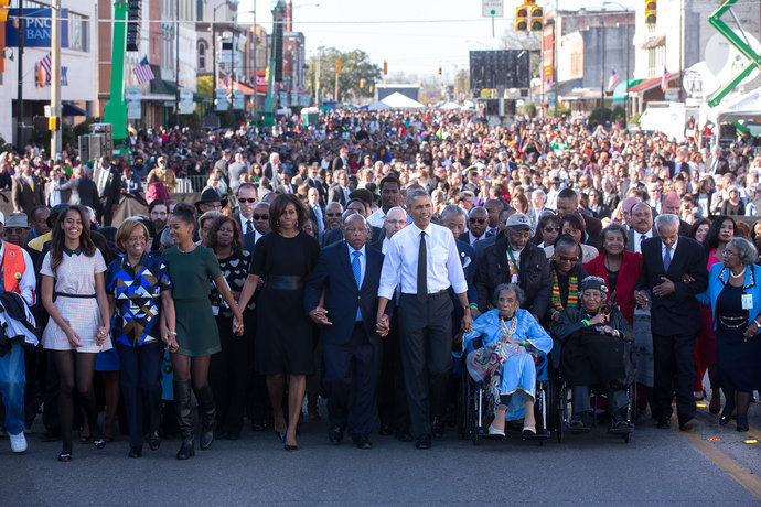 The Obamas hold hands with Rep. John Lewis (D-Ga.) as they begin the march across the Edmund Pettus Bridge to commemorate the 50th anniversary of “Bloody Sunday” in Selma, Alabama, March 7, 2015.  Official White House photo by Lawrence Jackson. 