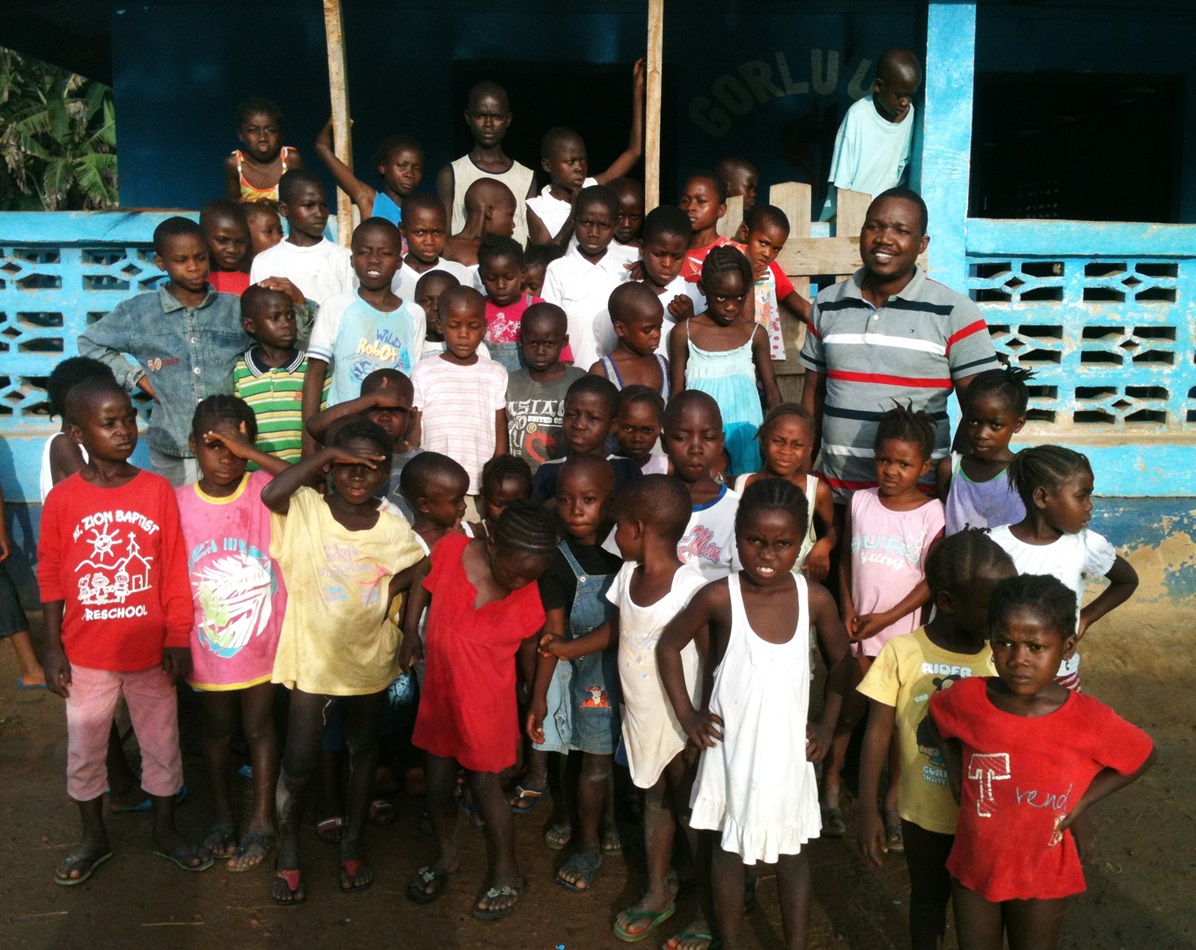 Jefferson Knight stands with a large group of children orphaned by Ebola. The children are living at the church’s Gorlu Care Center in Liberia. Photo by Julu Swen, UMNS