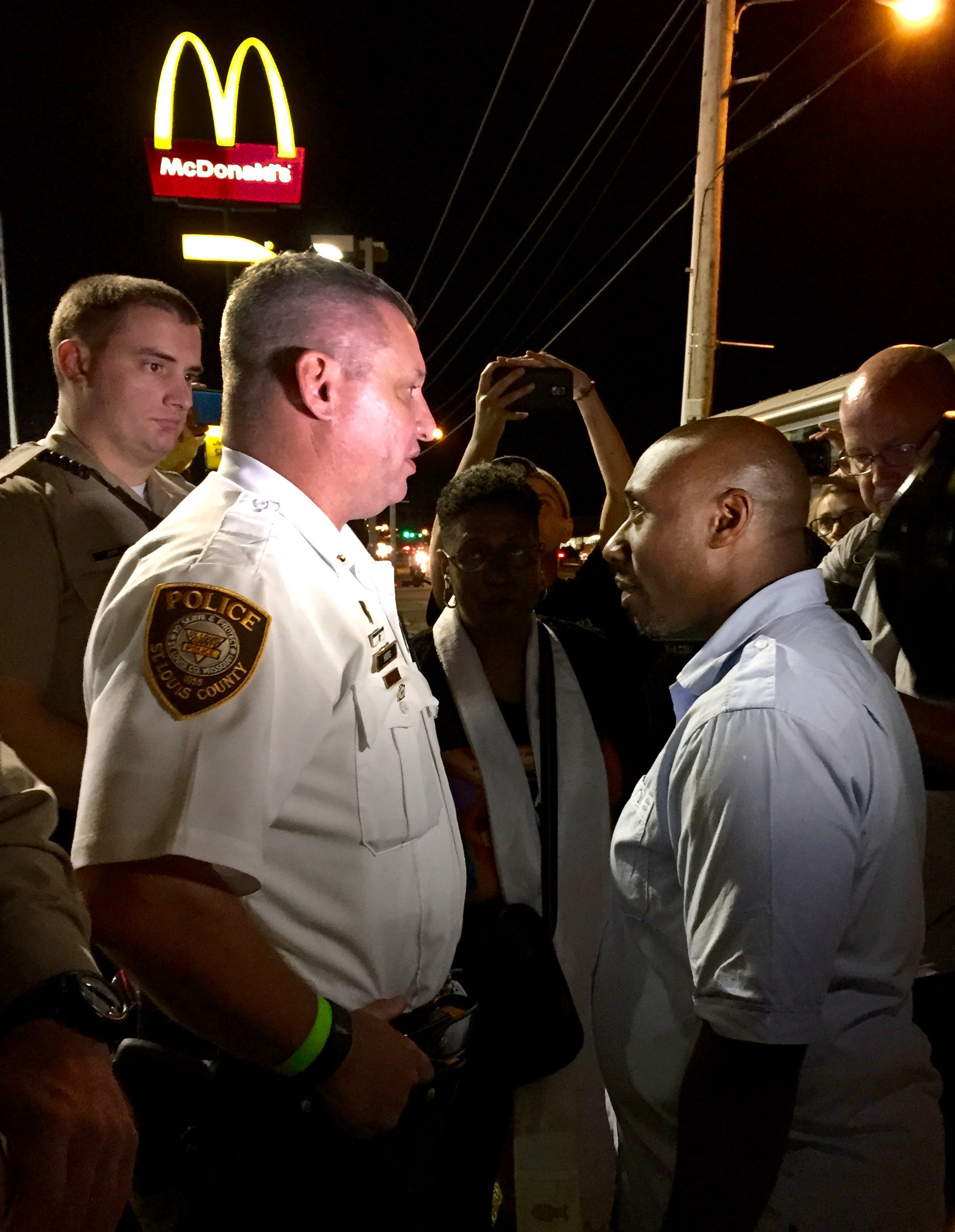 The Rev. F. Willis Johnson Jr., talks with a St. Louis County police officer about a United Methodist march in Ferguson, Mo. Photo by Kelley Hartnett