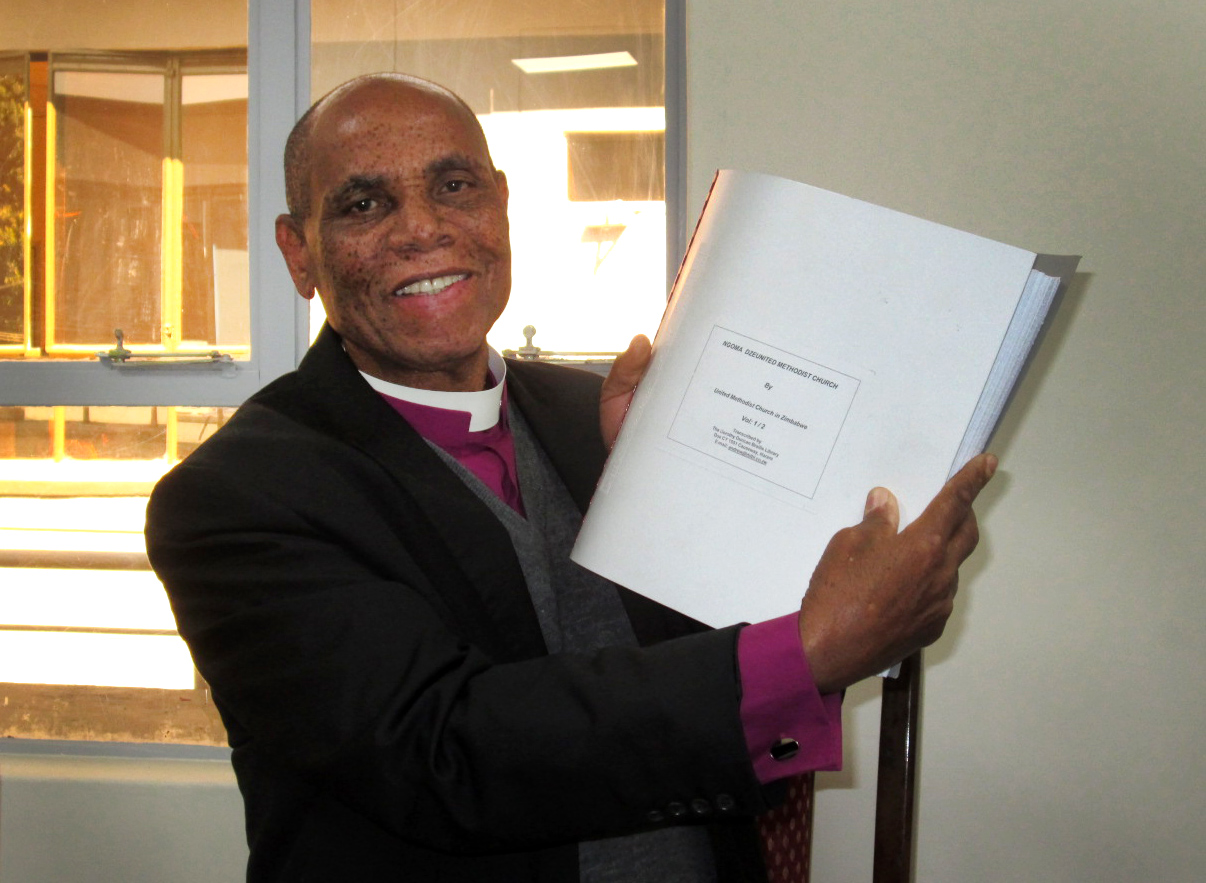 Bishop Eben Nhiwatiwa displays the new Braille Shona hymnal. Photo by Priscilla Muzerengwa, UMNS