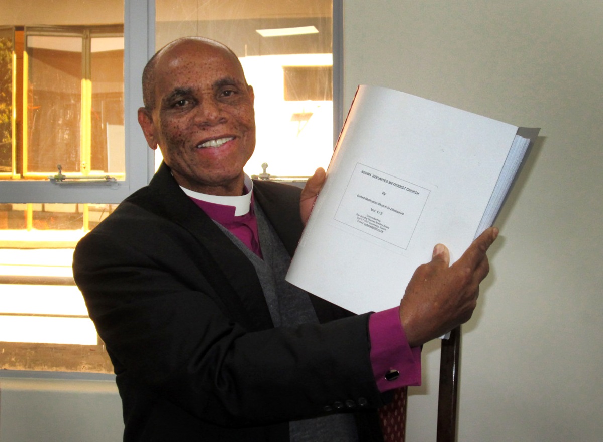 Bishop Eben Nhiwatiwa displays the new Braille Shona hymnal. Photo by Priscilla Muzerengwa, UMNS