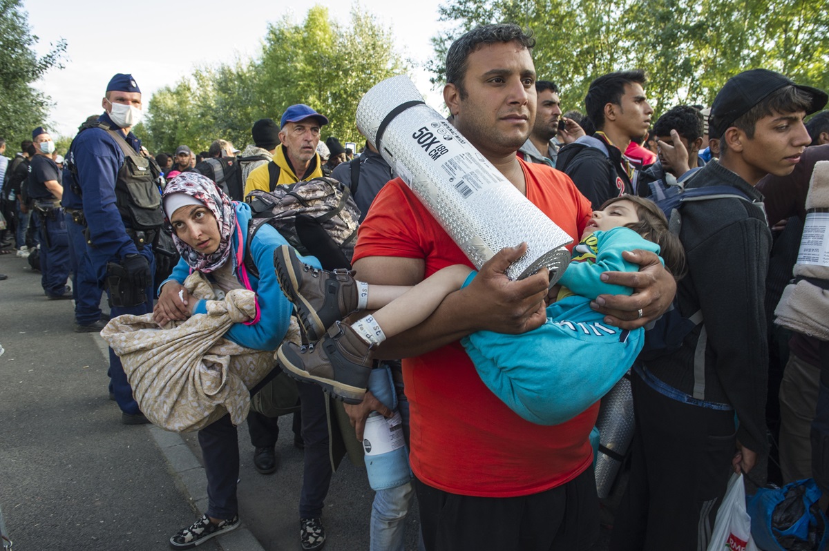 Refugees are halted on the way to a registration center in Hungary by the Serbian border.  Photo © UNHCR/Mark Henley