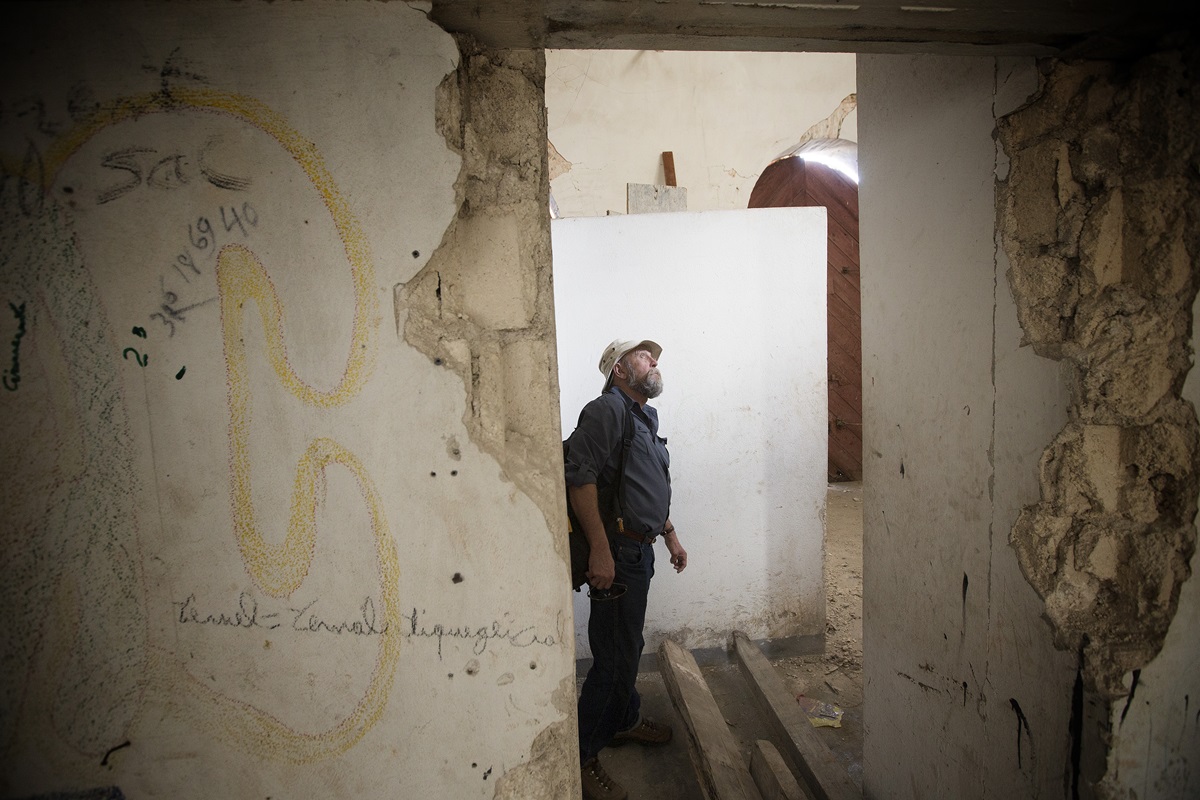 Warren McGuffin views damage remaining from the 2010 earthquake at the Methodist church in Petit-Goâve, Haiti. Several other buildings on the compound have been repaired. McGuffin is director of sustainability for the project. 2013 file photo by Mike DuBose, UMNS