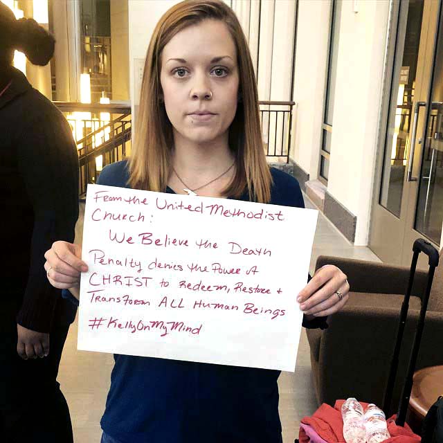 Brenna Lakeson, a Candler School of Theology student, holds a message about The United Methodist Church’s stance on the death penalty as part of a student-led public awareness campaign last spring.
