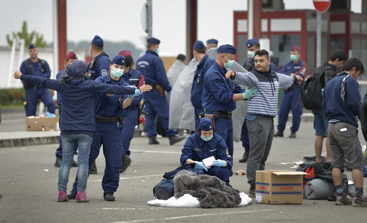 At a border crossing between Hungary and Croatia, Hungarian police and soldiers search incoming migrants. Photo by Paul Jeffrey for the ACT Alliance

