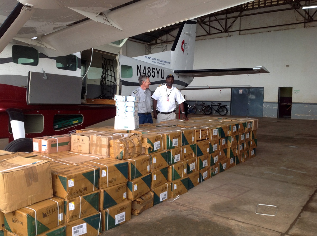 Pilot Gaston Ntambo and a friend look over boxes of fluids for rehydrating cholera patients. Ntambo was flying the fluids from Lumumbashi, Democratic Republic of Congo, to areas along the Congo River where there were cholera outbreaks. Photo courtesy of Betty Kazadi Musau
