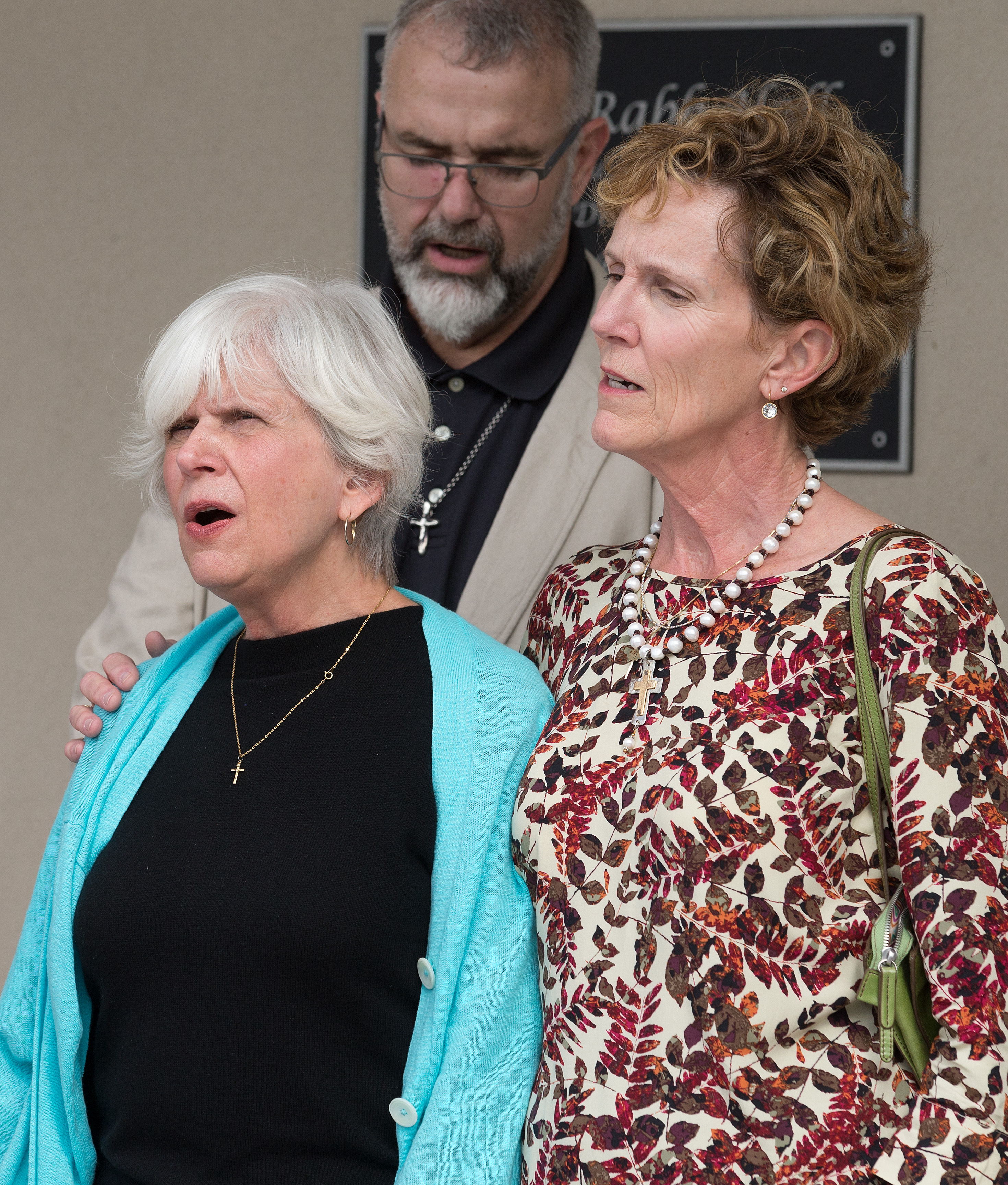Suzanne Rabb (left) and Cindy Dixon (right) sing a hymn during the dedication of Dixon Rabb Hall at the Sager Brown Depot in Baldwin, La. At rear is the Rev. Tom Hazelwood, former head of U.S. disaster response for UMCOR. Photo by Mike DuBose, United Methodist Communications.