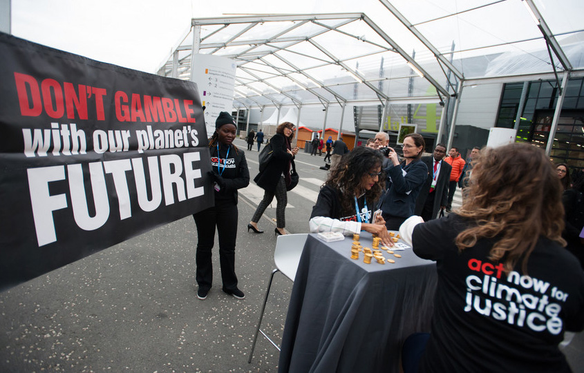 Climate justice activists organized by ACT Alliance stage a protest stunt during the U.N. climate summit in Paris, France. Photo by Ryan Rodrick Beiler/LWF, courtesy of World Council of Churches