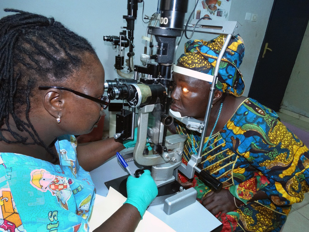 Cataract surgeon Isatu Sesay examines Aminata Bangura’s eyes at the Lowell and Ruth Gess United Methodist Eye Hospital in eastern Freetown. Bangura is an Ebola survivor receiving free treatment.