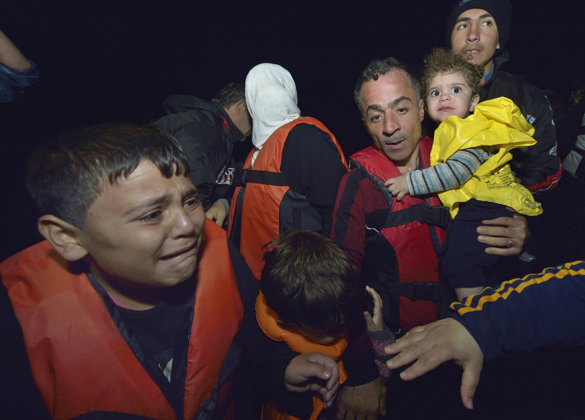 Refugees disembark at night from a private fishing boat that rescued them at sea, bringing them into the harbor at Skala Sikaminia, on the Greek island of Lesbos, on November 1, 2015.  A seven-person United Methodist group traveled to Lesbos in January to help care for such refugees. Photo by Paul Jeffrey.