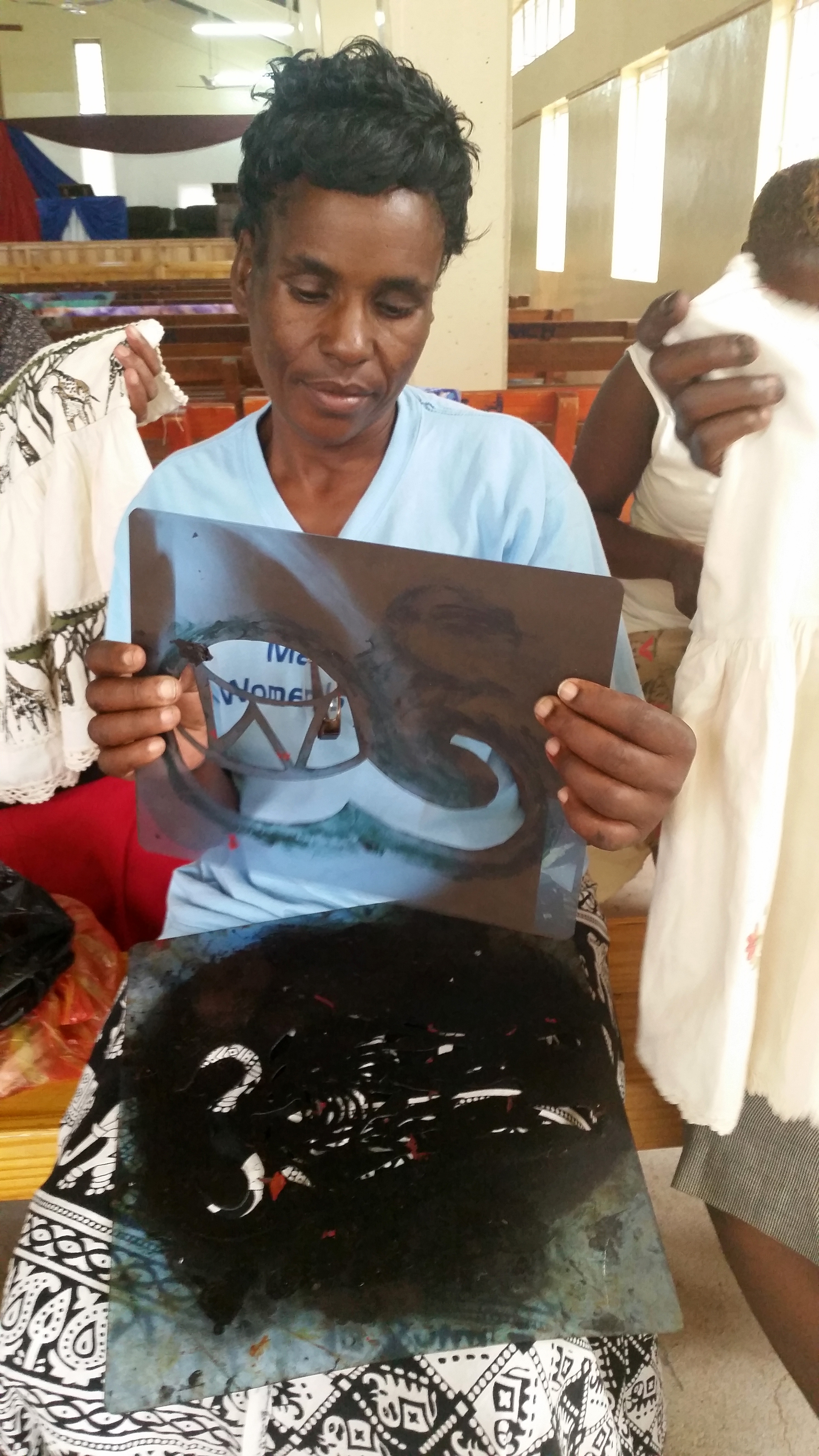 Emilia Mafuratidze holds an X-ray film that she is recycling as a stencil to print fabric during a workshop  in Zimbabwe held by the Chitungwiza-Marondera District women’s union March 1-3, 2016. Photo by Eveline Chikwanah, UMNS 