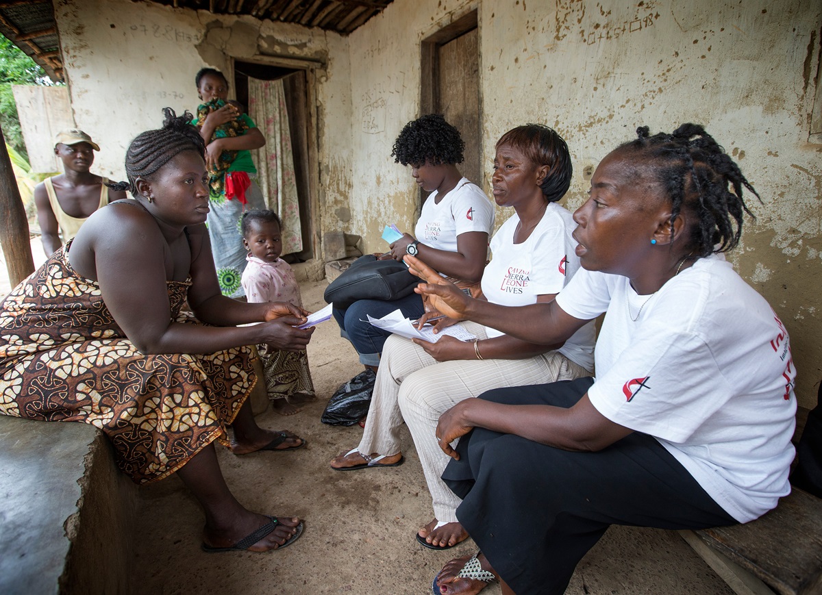 Health worker Kadie E. Koroma (right), part of a team with the United Methodist Church's Imagine No Malaria campaign, processes a voucher that will provide mosquito nets for the family of Gbassay Foday (seated at left) for her home in Baoma village, near Bo, Sierra Leone, in June 2014. The campaign had raised more than $68 million by the end of 2015. File photo by Mike DuBose, UMNS