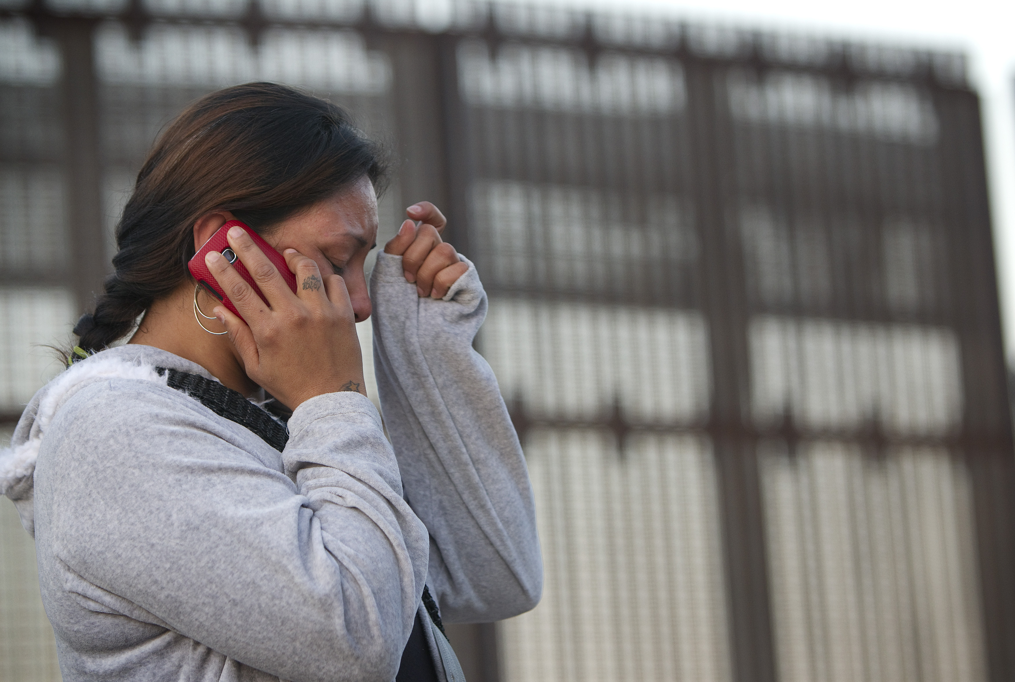 Nancy, who was deported from the U.S. after a traffic violation, cries as she speaks with her mother in Los Angeles from the Mexican side of the massive border fence in Tijuana in December 2012. 