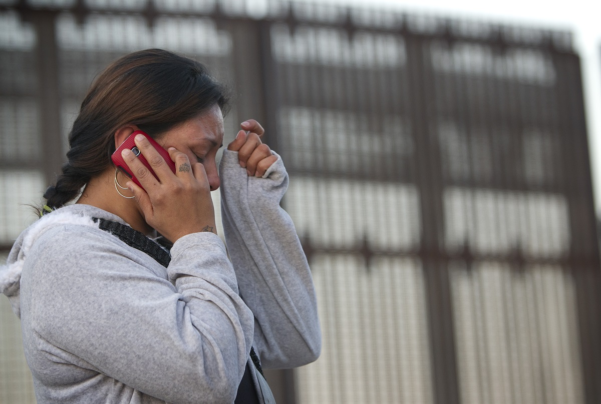 Nancy, who was deported from the U.S. after a traffic violation, cries as she speaks with her mother in Los Angeles from the Mexican side of the massive border fence in Tijuana in December 2012. 