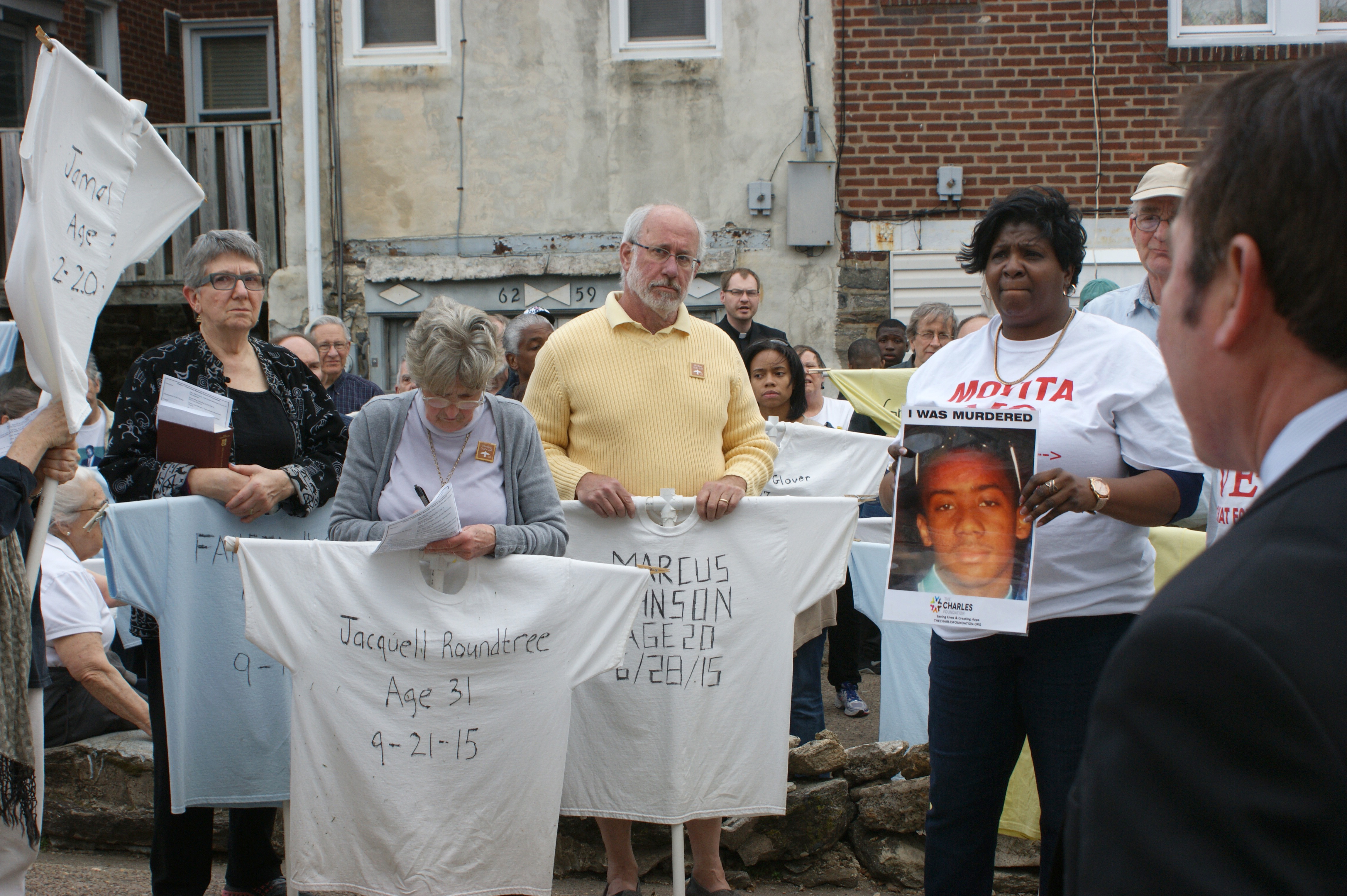 Participants of many faiths pick up shirts of the Memorial to the Lost in preparation for carrying them in the walk on Good Friday, March 25 in Philadelphia organized by Heeding God’s Call to End Gun Violence. 