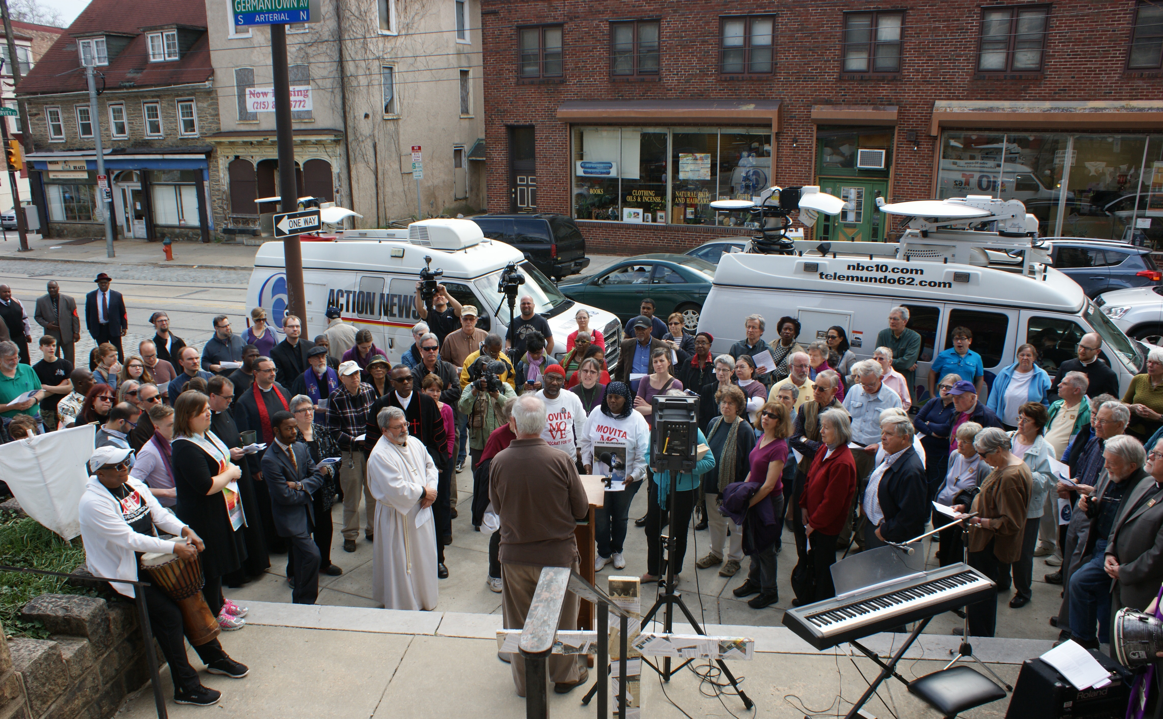 A crowd of more than 200 people of many faiths listens prior to walking through Philadelphia's gun damaged Germantown neighborhood.