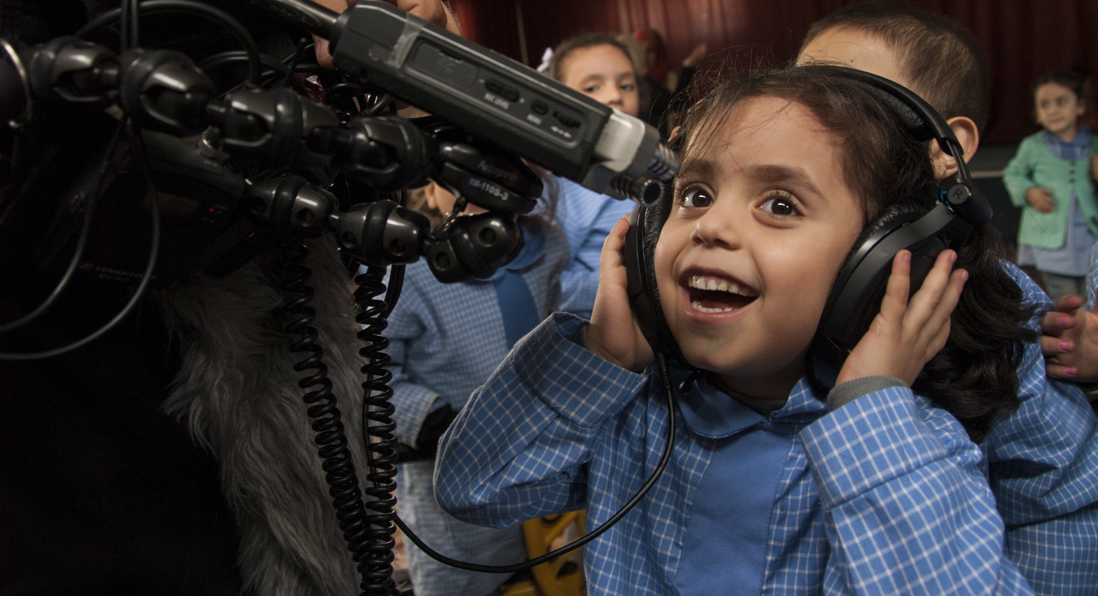 A Syrian girl at a school in the refugee camp of Bourj el-barajneh in Beirut in 2015 has fun with the "Beyond Bethlehem" crew's audio gear. A 2015 file photo courtesy of Dan Bracken