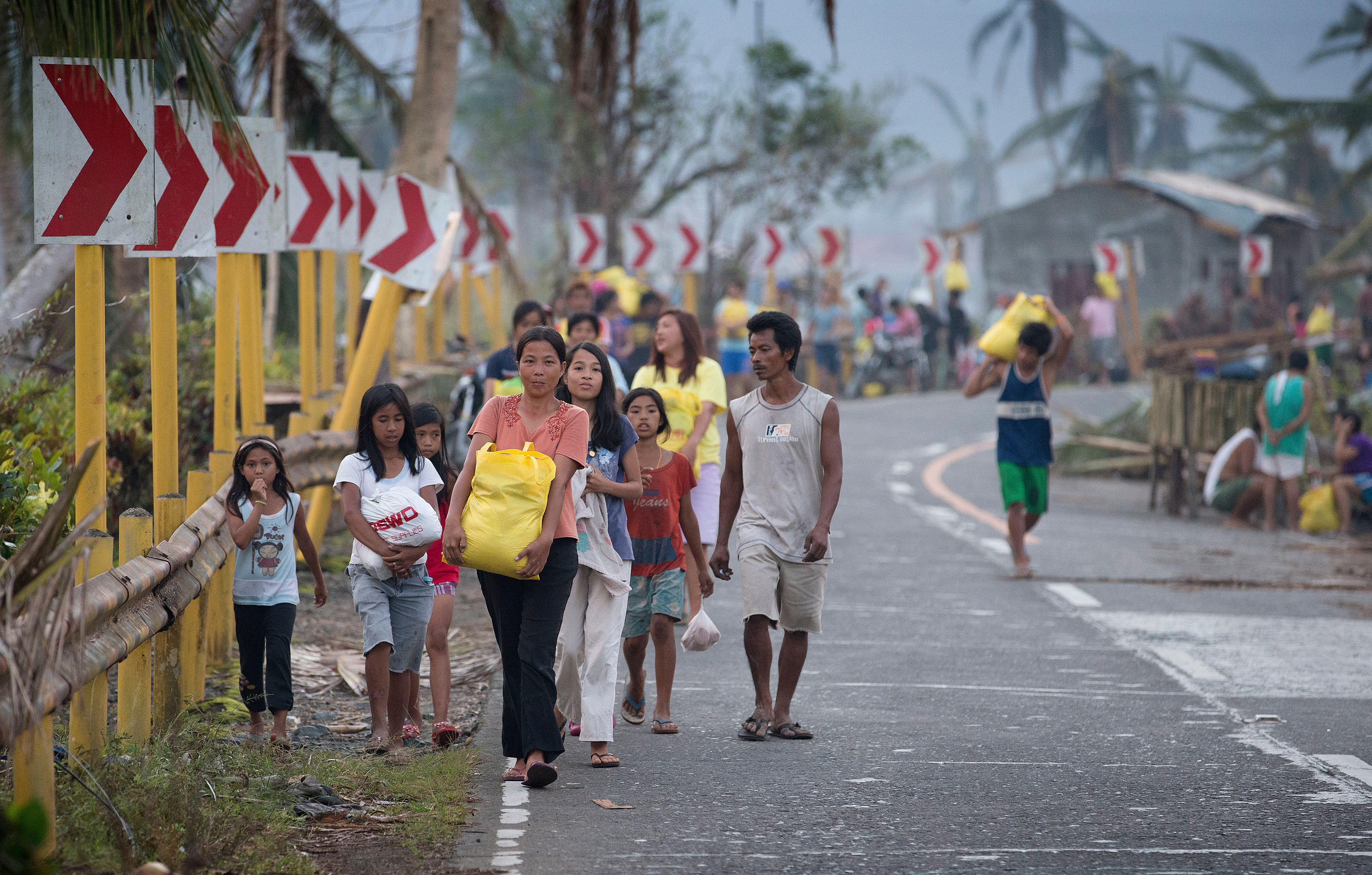 Survivors of Typhoon Haiyan leave with emergency food rations provided by the United Methodist Committee on Relief following a distribution in Dagami, Philippines, in 2013. File photo by Mike DuBose, UMNS