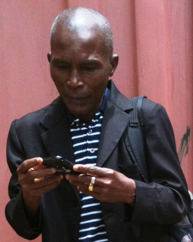 Julu Swen in Monrovia, Liberia, receives a text message on Ebola, written by Liberia Area Bishop John G. Innis. United Methodist Communications transmitted information. 