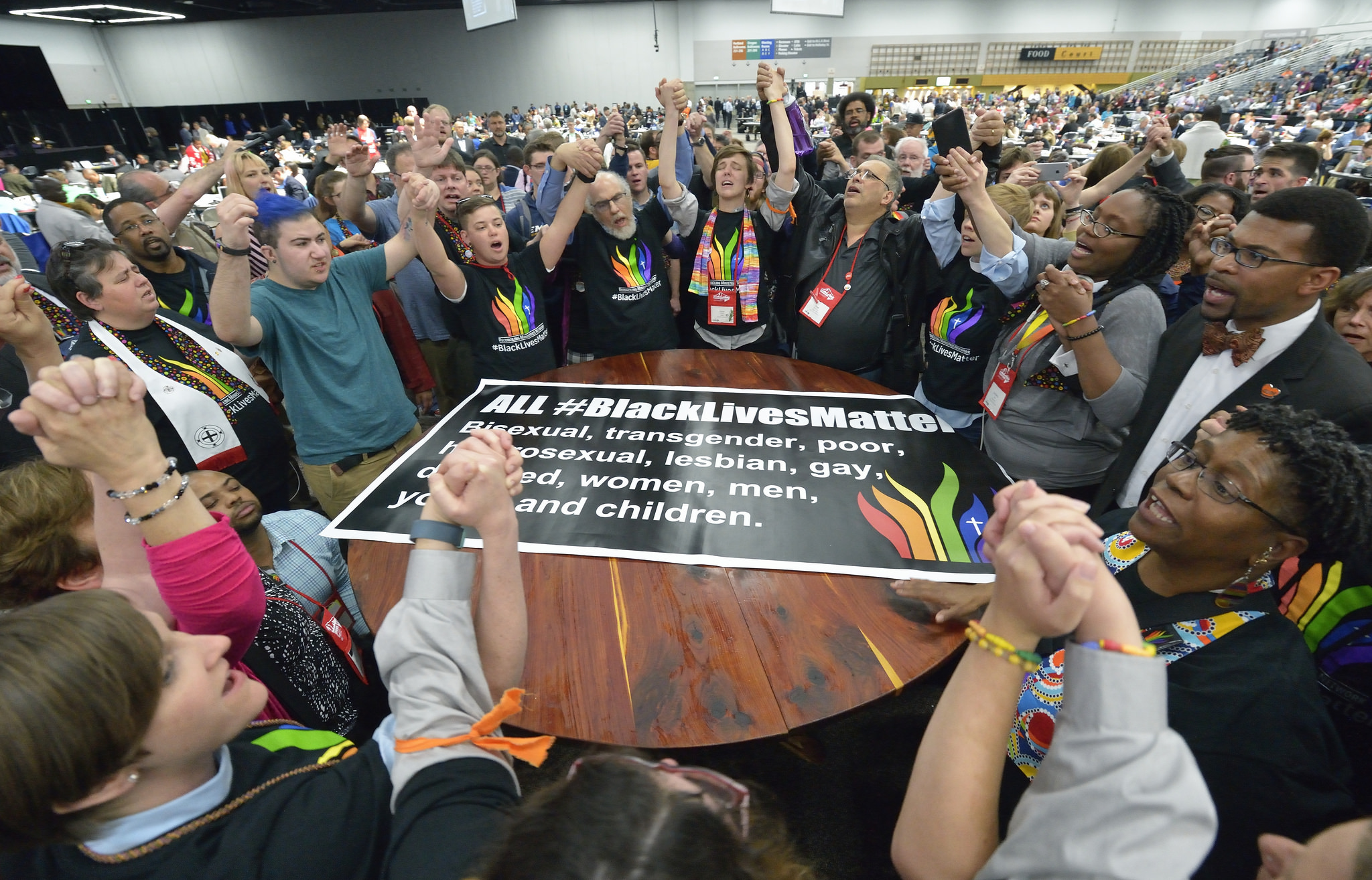 Members of the Black Lives Matter movement disrupt the May 16 proceedings of the 2016 United Methodist General Conference in Portland, Ore. The demonstrators marched into the plenary session chanting slogans and gathered around the central communion table. Photo by Paul Jeffrey, UMNS.