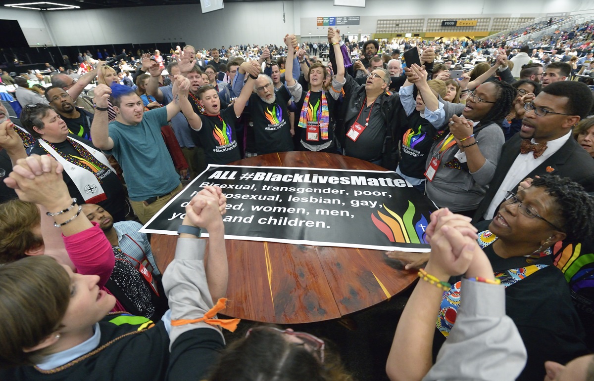 Members of the Black Lives Matter movement disrupt the May 16 proceedings of the 2016 United Methodist General Conference in Portland, Ore. The demonstrators marched into the plenary session chanting slogans and gathered around the central communion table. Photo by Paul Jeffrey, UMNS.
