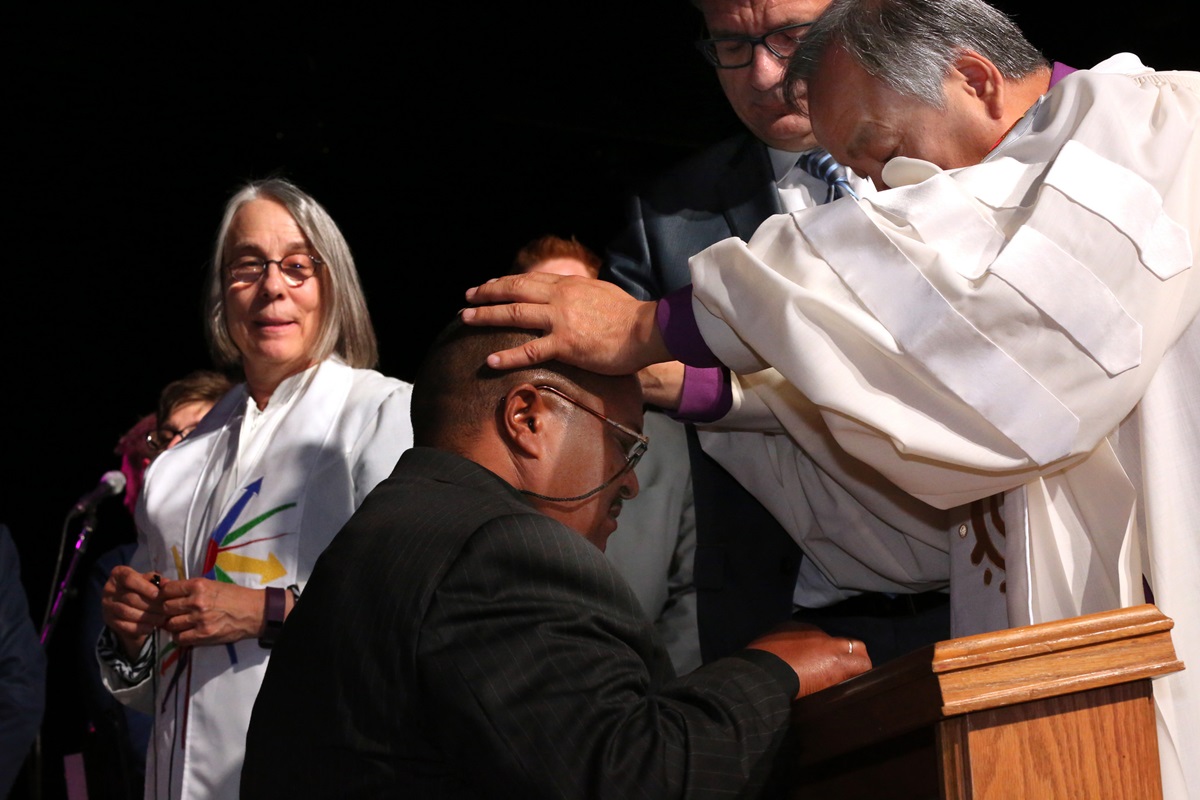 Bishop Hee-Soo Jung commissions Leo Garcia as a missionary May 19 at the 2016 United Methodist General Conference in Portland, Ore. In the background are Catherine Whitlatch and Thomas Kemper from the United Methodist Board of Global Ministries. Photo by Kathleen Barry, UMNS