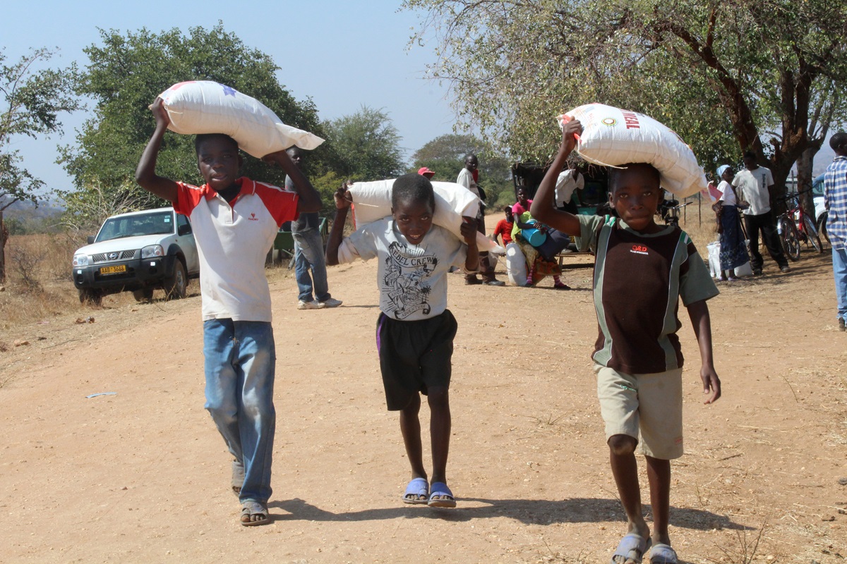Young boys leave Rutuka United Methodist Church in Rushinga, Zimbabwe, with bags of meal. The denomination organized food distributions to help those in drought-ravaged areas. A UMNS photo by Eunice Kadiki