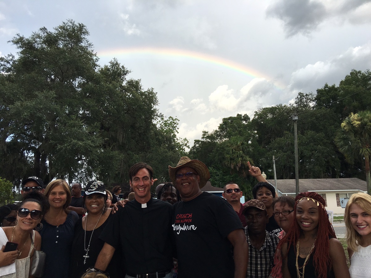 At the end of an ecumenical “Prayer Walk for Racial Peace,” organizers and some marchers are shown under one of the rainbows that came out at the end of the march. Photo courtesy of Michael Beck