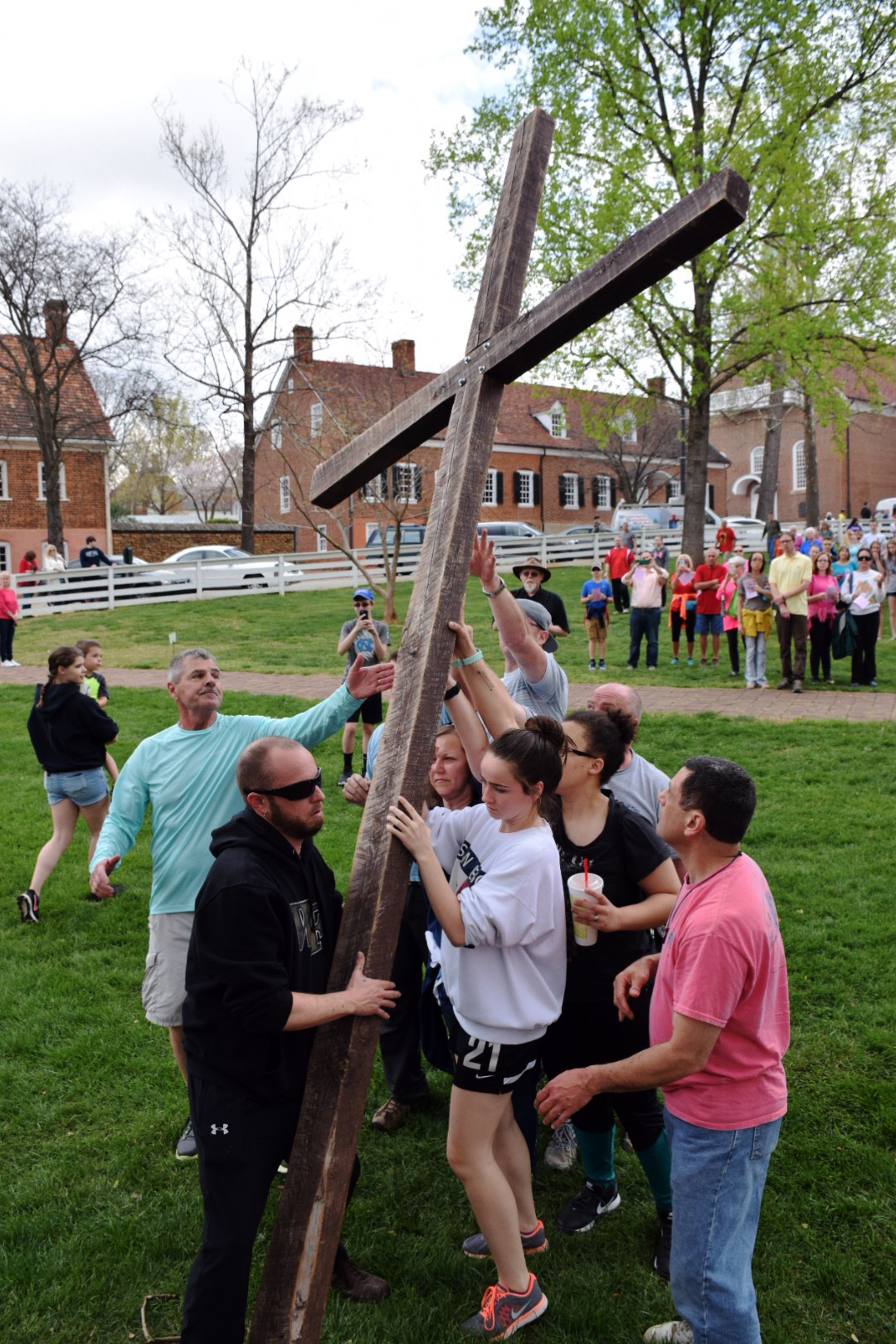 Participants in Trinity Moravian Church's annual Good Friday Crosswalk in Winston-Salem, N.C., raise the cross in Salem Square. Photo by Andrew David Cox, Moravian BCM
