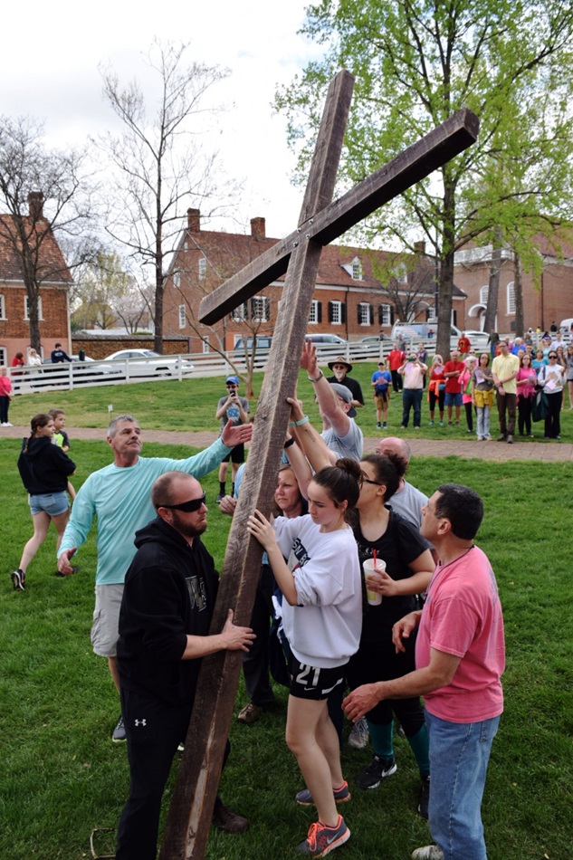 Participants in Trinity Moravian Church's annual Good Friday Crosswalk in Winston-Salem, N.C., raise the cross in Salem Square. Photo by Andrew David Cox, Moravian BCM