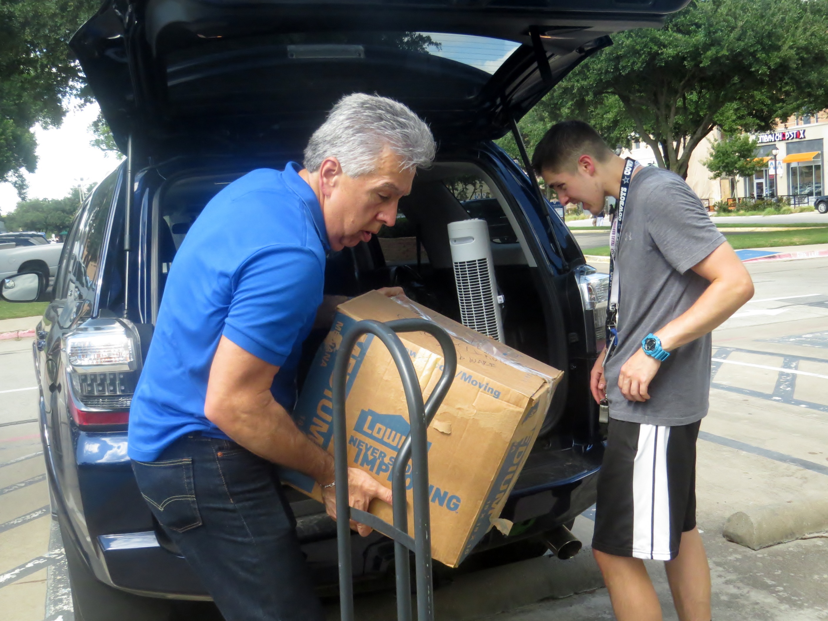 Bishop Ruben Saenz Jr. helps son Isaac unload boxes on Aug. 23 at the University of Texas at Arlington. Photo by Sam Hodges, UMNS