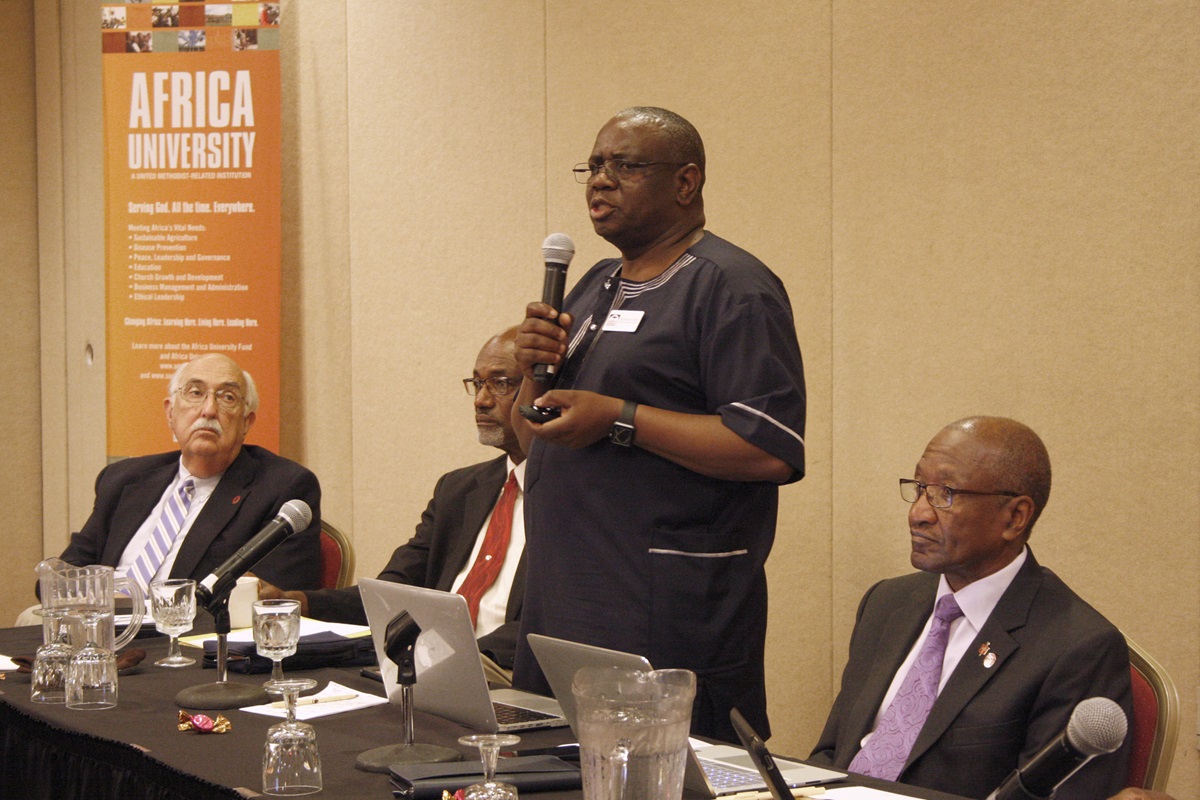 Munashe Furusa, vice chancellor of Africa University, said the United Methodist university is open and operating smoothly despite political unrest in Zimbabwe, although some students have been unable to register for financial reasons. Retired Bishops J. Lawrence McClesky (left) and Ernest Lyght (middle left) and Marcus Matthews (right) listen to Furusa’s report. Photo by Vicki Brown, UMNS.