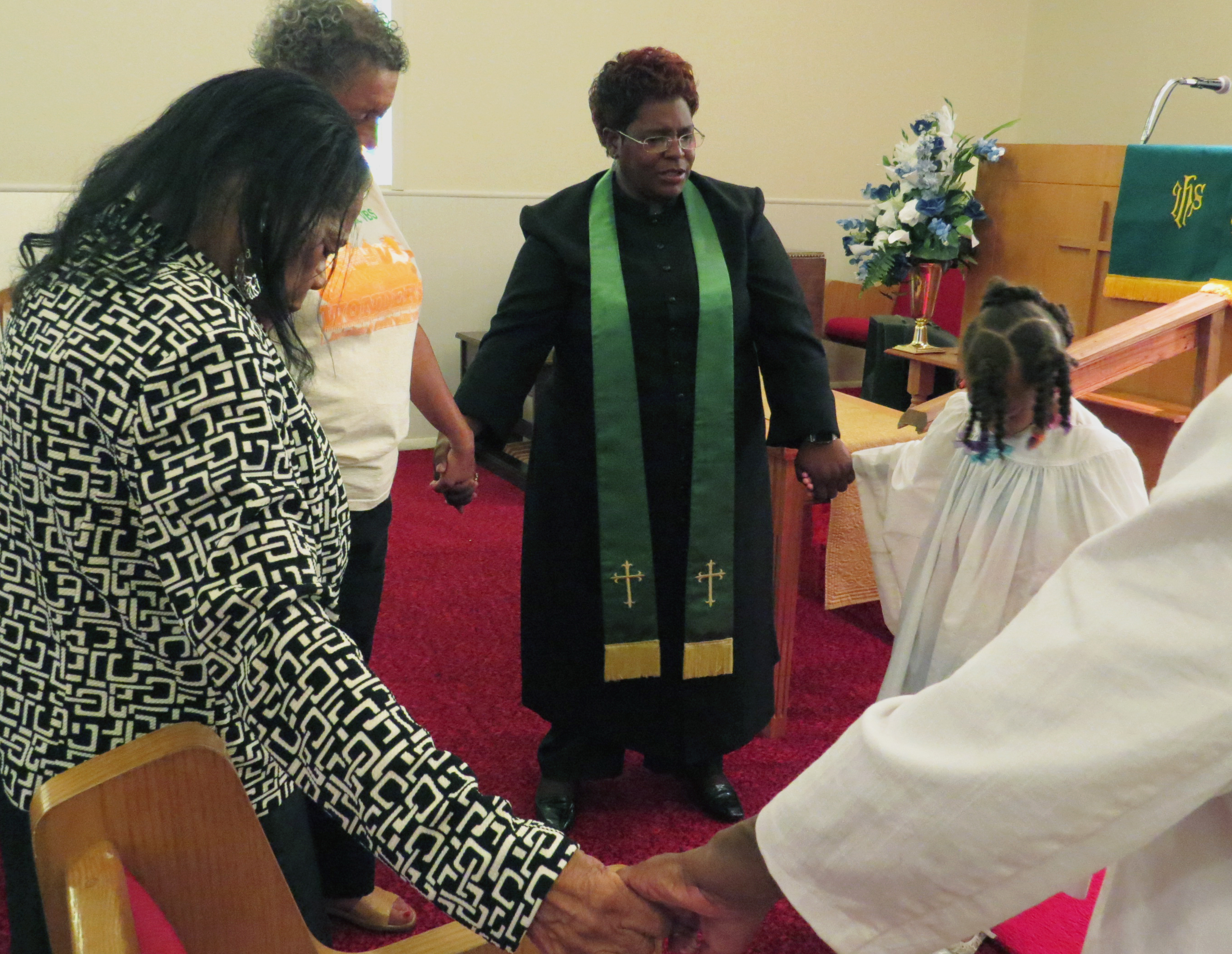 The Rev. Doris Smith leads some members of Warren Chapel United Methodist Church, in Terrell, Texas, in prayer on Sept 11. Smith is a full-time Dallas police detective and serves as the church’s part-time pastor. Photo by Sam Hodges, UMNS.