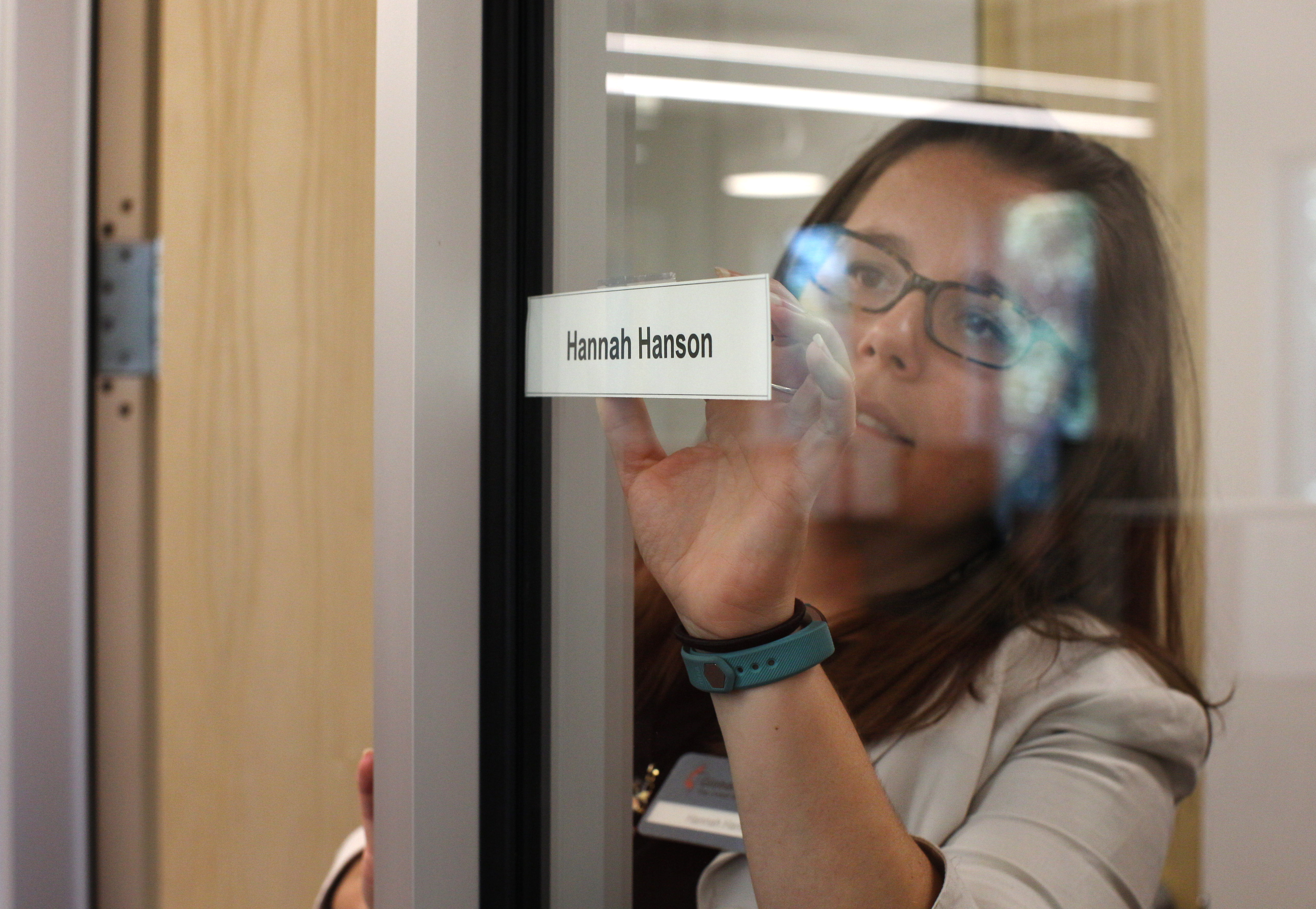 Hannah Hanson, director of young adult mission service, places her name tag on her new office in Atlanta. 
