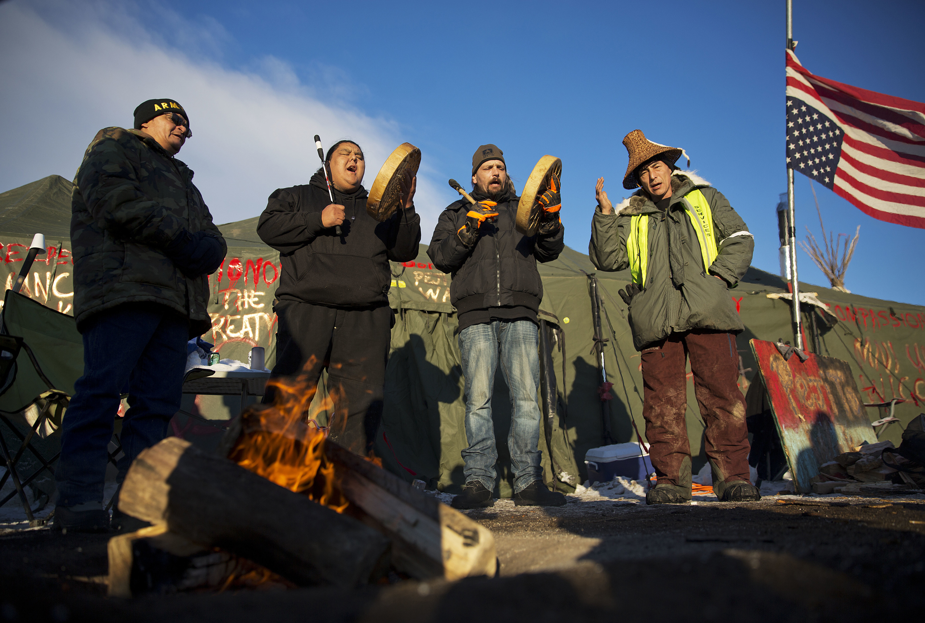 Native Americans from left, Eugene Sanchez, Jason Umtuch, Martan Mendenhall, and Hugh Ahnatock, all of Portland, Ore., drum and sing at the Oceti Sakowin camp where people have gathered to protest the Dakota Access oil pipeline in Cannon Ball, N.D., Sunday, Dec. 4, 2016. The U.S. Army Corps of Engineers said Sunday that it won't grant an easement for the Dakota Access oil pipeline in southern North Dakota, handing a victory to the Standing Rock Sioux tribe and its supporters, who argued the project would threaten the tribe's water source and cultural sites. Photo by David Goldman, AP