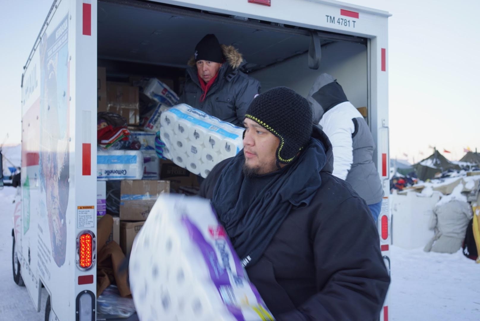 Members of the Oklahoma Indian Missionary Conference, including the Rev. David Wilson (left, in truck) and Justin Phillips, deliver supplies to water protectors at the Standing Rock Sioux base camp near Cannon Ball, N.D. Photo by Allen Buck 