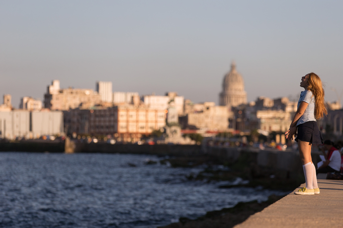 A student stops to sing from atop the Malecón seawall in Havana. Photo by Mike DuBose, UMNS.